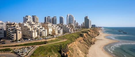 Paesaggio costiero con edifici alti, una spiaggia e una strada a curve.