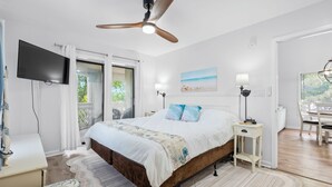 A bedroom with a bed, a ceiling fan, a TV, a desk, and a chair. - Coastal Penthouse Paradise Indoor Heated Pool Marsh View (Myrtle Beach)