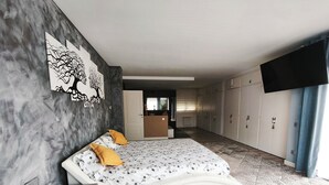 A bedroom with a bed, a wardrobe, a desk, and a painting on the wall. - Villa with a private pool, 25 minutes from Barcelona (Vallromanes), near the F1 circuit (Vallromanes)