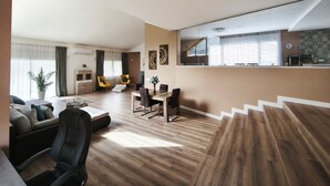 A modern living room with a sofa, a dining table, and chairs. There is a kitchen area with a counter and a window. - Villa with a private pool, 25 minutes from Barcelona (Vallromanes), near the F1 circuit (Vallromanes)