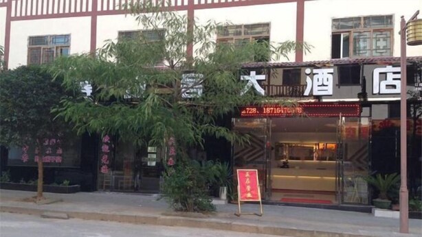 Un hotel con fachada tradicional, entrada visible y cartel con texto.