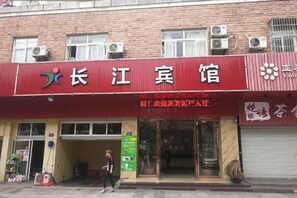 A red building with a sign that reads 'Long Jiang Guest House.' - Changjiang Hotel (Ningbo)