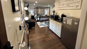 Una cucina moderna con frigorifero, microonde e zona pranzo con tavolo e sedie.