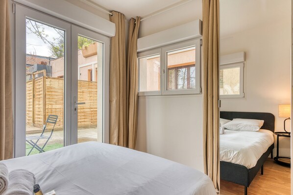 A bedroom with a bed, a window, and a view of the outside.
