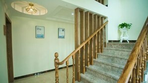 Eine Treppe mit Holzspindeln und Handlauf, die zu einer oberen Etage führt.