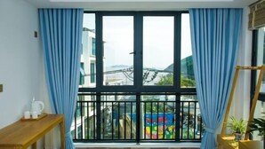 Ein Balkon mit Blick auf ein farbenfrohes Wandgemälde und ein Gebäude gegenüber.