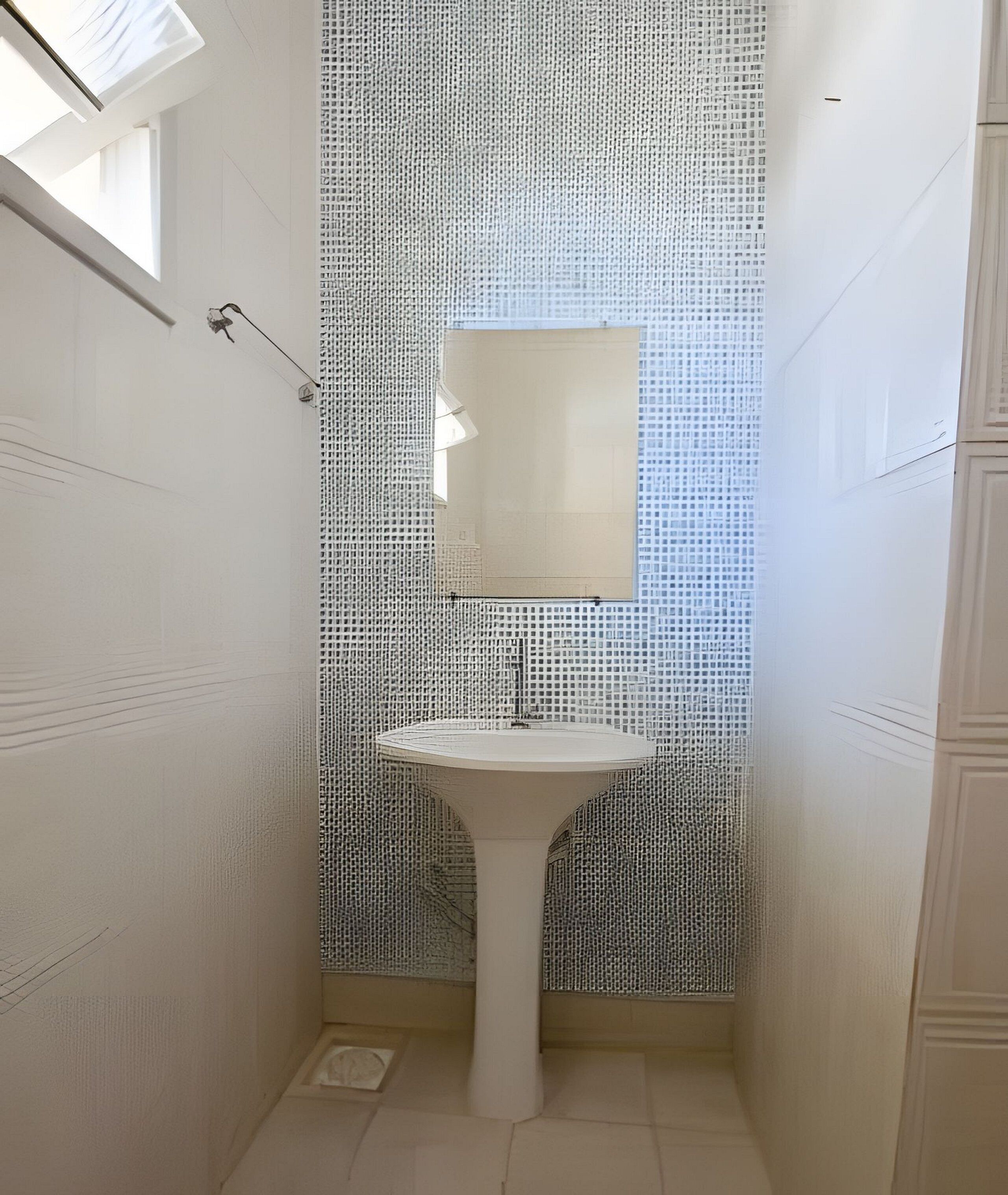A narrow bathroom with a white sink and a mirror on the wall.