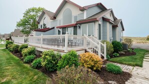 A two-story house with a covered porch and a fenced deck.