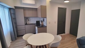 A compact living space with a kitchenette, a dining area with a round table and two chairs, and a sofa. - Berni Rentals Ciudad Vieja (Montevideo)