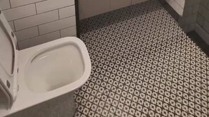 A bathroom with a toilet, sink, and mirror. - Berni Rentals Ciudad Vieja (Montevideo)