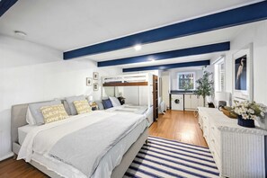 Une chambre moderne avec un lit superposé, une petite kitchenette et une salle de bain.