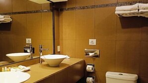 A modern bathroom with a large sink, a toilet, and a mirror. - Hotel & Suites Virreynal (Teziutlán)