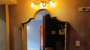 A large mirror with a decorative frame in a hallway with wooden flooring. - Hotel & Suites Virreynal (Teziutlán)