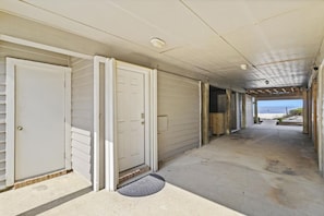 Un paseo techado que conduce a casas frente al mar, con vista al océano.