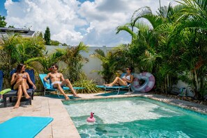 A swimming pool with lounge chairs and a flamingo float.