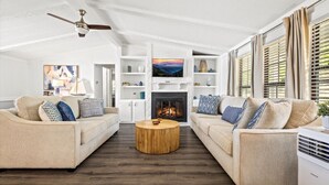 A spacious living room with two beige sofas, a wooden coffee table, and a fireplace. - Lakefront Oasis- Steps to Water- Private Boat Ramp (Dandridge)