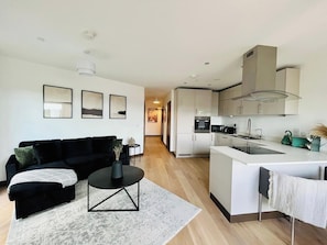A modern apartment with a living area, kitchen, and dining space.