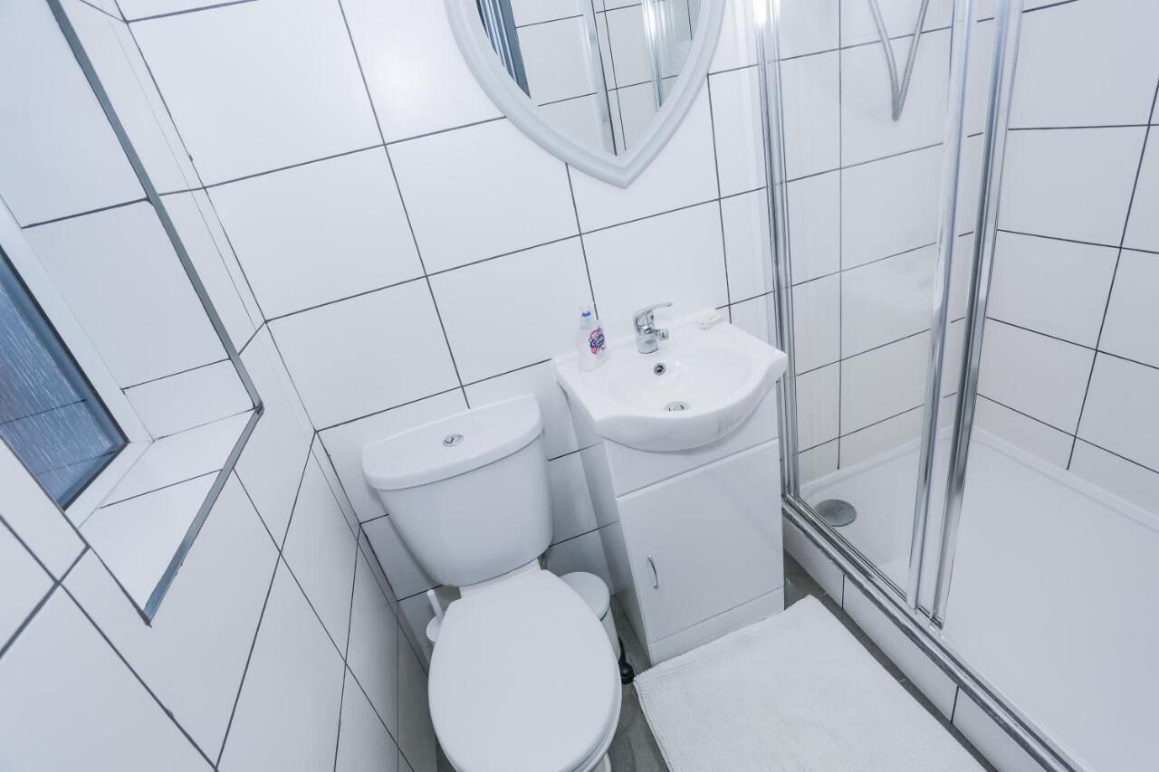 Un baño moderno con inodoro, lavamanos y ducha.