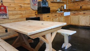 A wooden kitchen with a central island, a microwave, and a hanging bag of rice. - Hidden in East Texas Piney Woods - Rustic Western Cabin - Canton 1st Monday (Mineola)