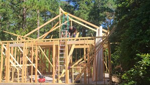 Una estructura de madera con una escalera, rodeada de árboles.