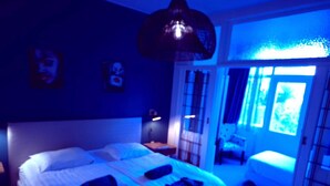 Un dormitorio con una cama grande, una mesita de noche y una lámpara colgante.