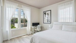 Una habitación de hotel con una cama, un escritorio, una silla y un televisor.
