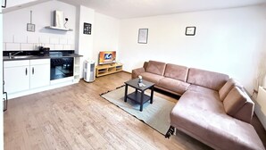 Un apartamento moderno con cocina, sala de estar y un amplio ventanal.