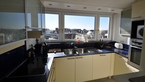 Eine moderne Küche mit großem Fenster, einer Spüle und einem Herd.