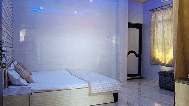 Een moderne slaapkamer met een bed, een plafondventilator, inbouwverlichting en een raam met gordijnen.