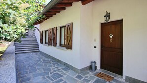Una scala in pietra conduce a una porta di legno con un tappetino di benvenuto.