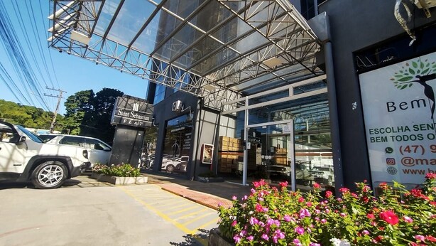 A modern building with a glass facade and a sign for Saint Sebastian Flat. - Saint Sebastian ap102 - stúdio (Jaragua do Sul)