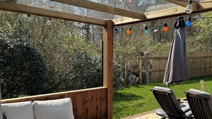 An outdoor deck with a wooden bench, a sofa, and two chairs. - Big house in a secluded area in beautiful Skanör (Skåne län)