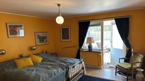A bedroom with a bed, a desk, a chair, and a window with curtains. - Big house in a secluded area in beautiful Skanör (Skåne län)