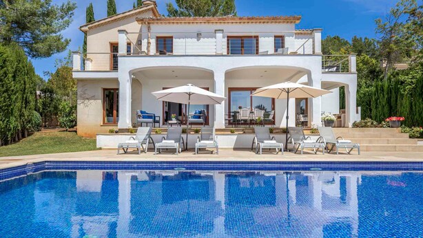 Una casa de dos pisos con piscina, mobiliario exterior y jardín.