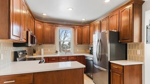 Una cocina moderna con armarios de madera, electrodomésticos de acero inoxidable y una isla grande.
