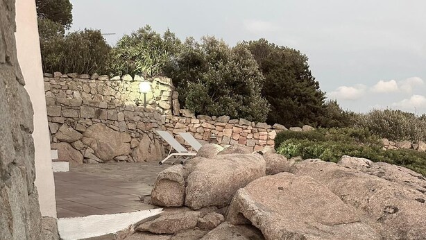 Un sentiero di pietra conduce a un muro in pietra con delle gradinate.