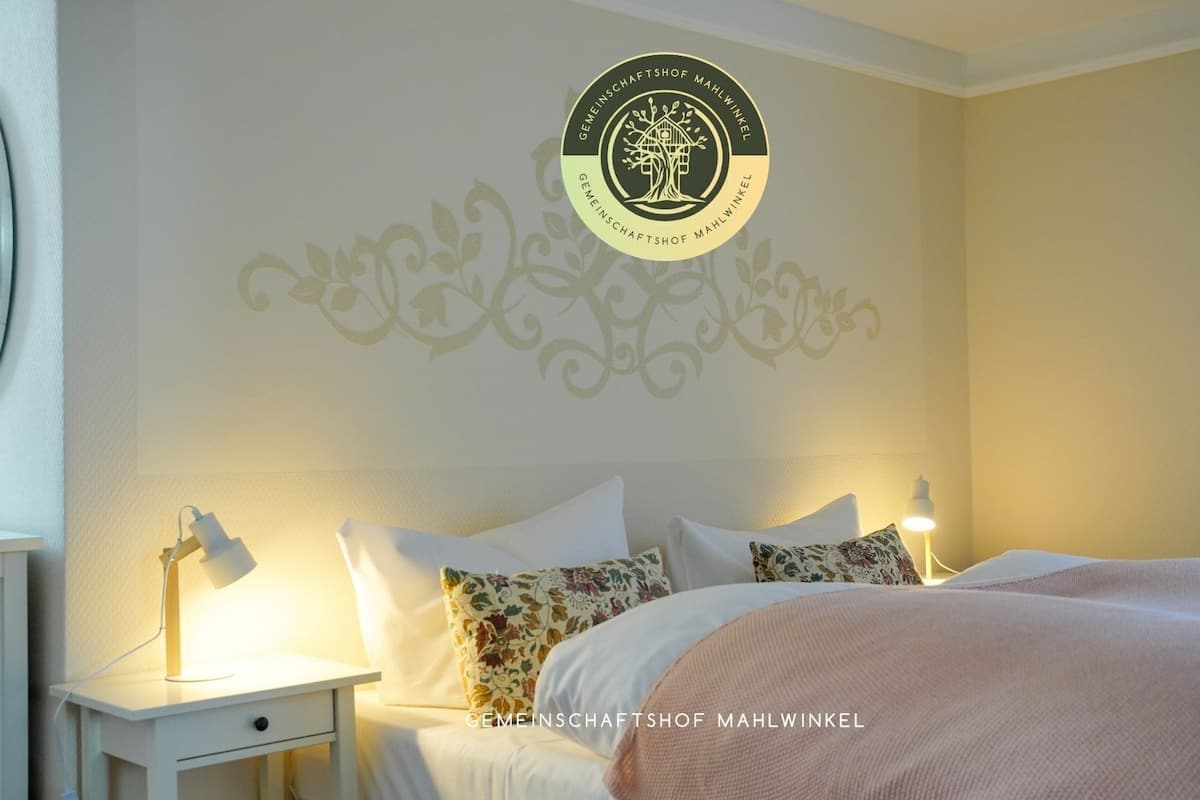 A hotel room with a bed, nightstands, and a decorative wall design.