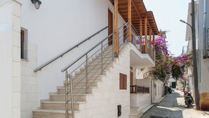 Una calle estrecha con una escalera que lleva a un edificio con balcón.