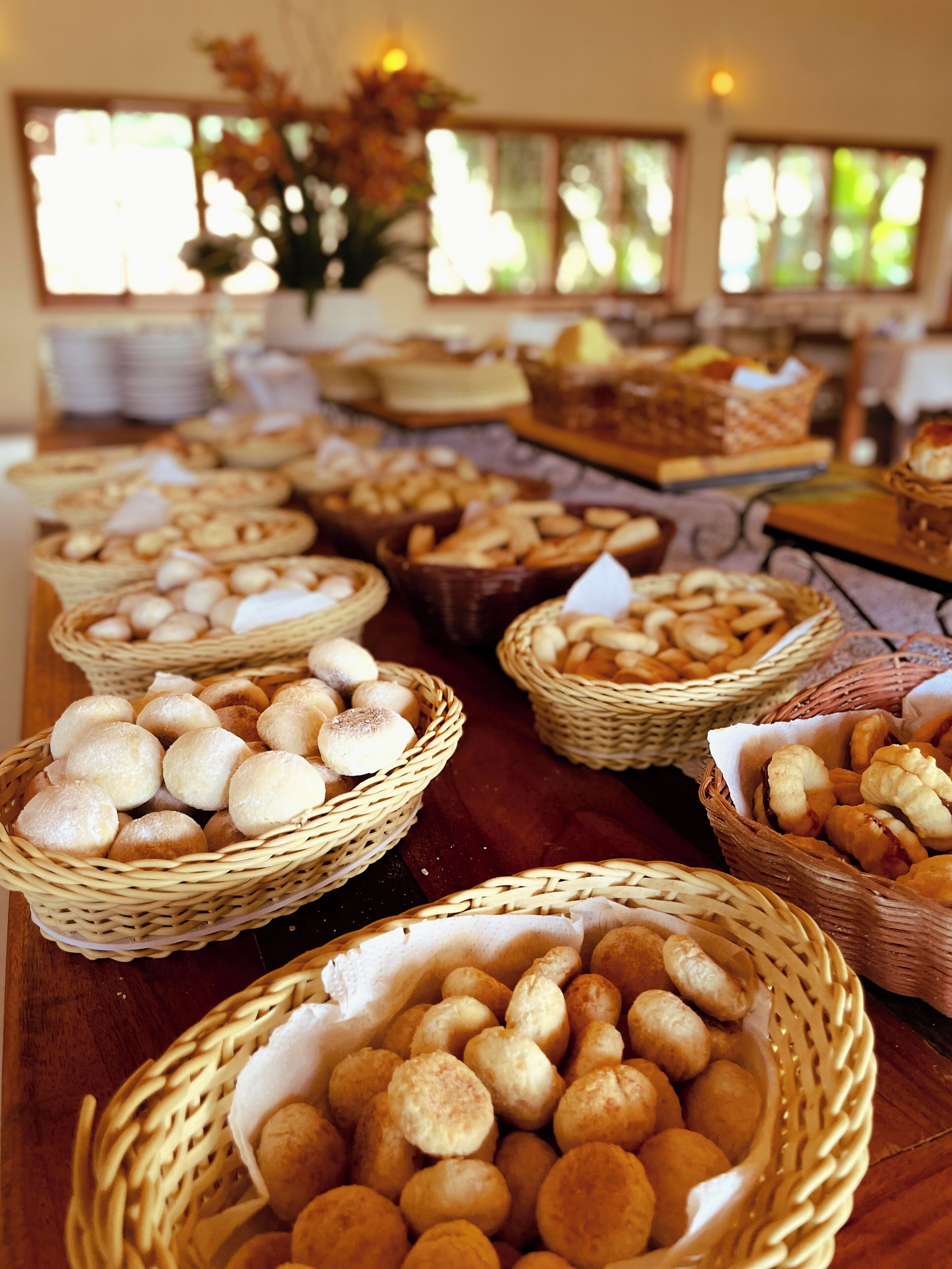 Una taula de buffet amb diferents cistells de pa i pastissos.