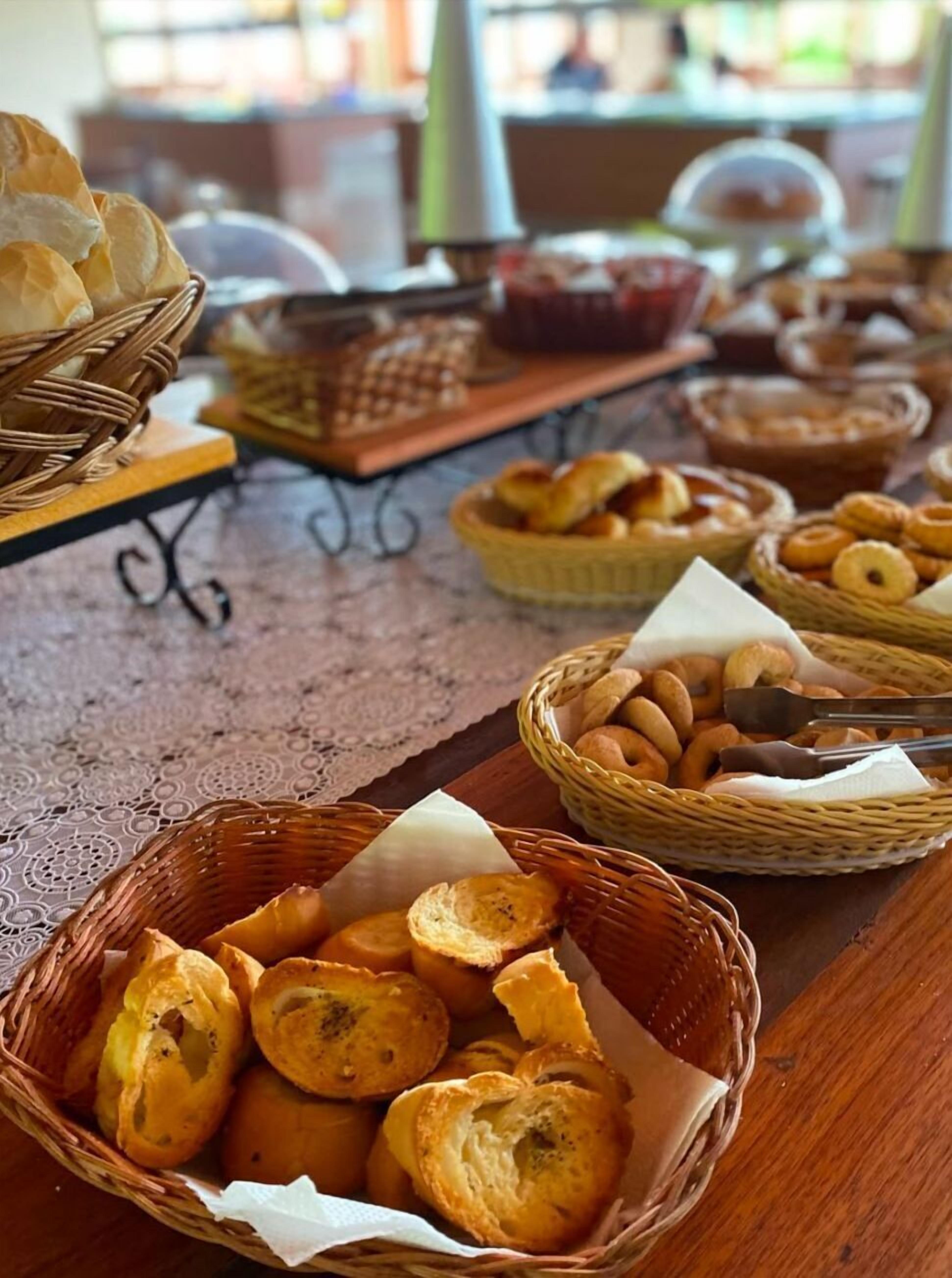 A table with various baskets containing bread and pastries.