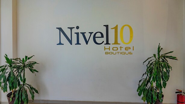 A sign for 'Nivel10 Hotel Boutique' with two potted plants on either side. - Motel & Hotel Nivel 10 (Manzanillo)