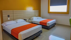 A hotel room with two beds, a window, and a nightstand with a phone. - Motel & Hotel Nivel 10 (Manzanillo)