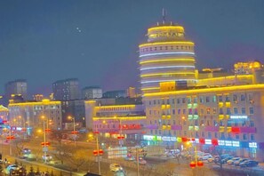A cityscape at night with illuminated buildings and a busy street. - No.5 Theme Hotel (Yanji)