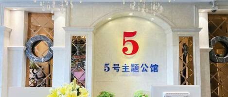A reception area with a prominent number 5 sign, a marble reception desk, and a modern chandelier.