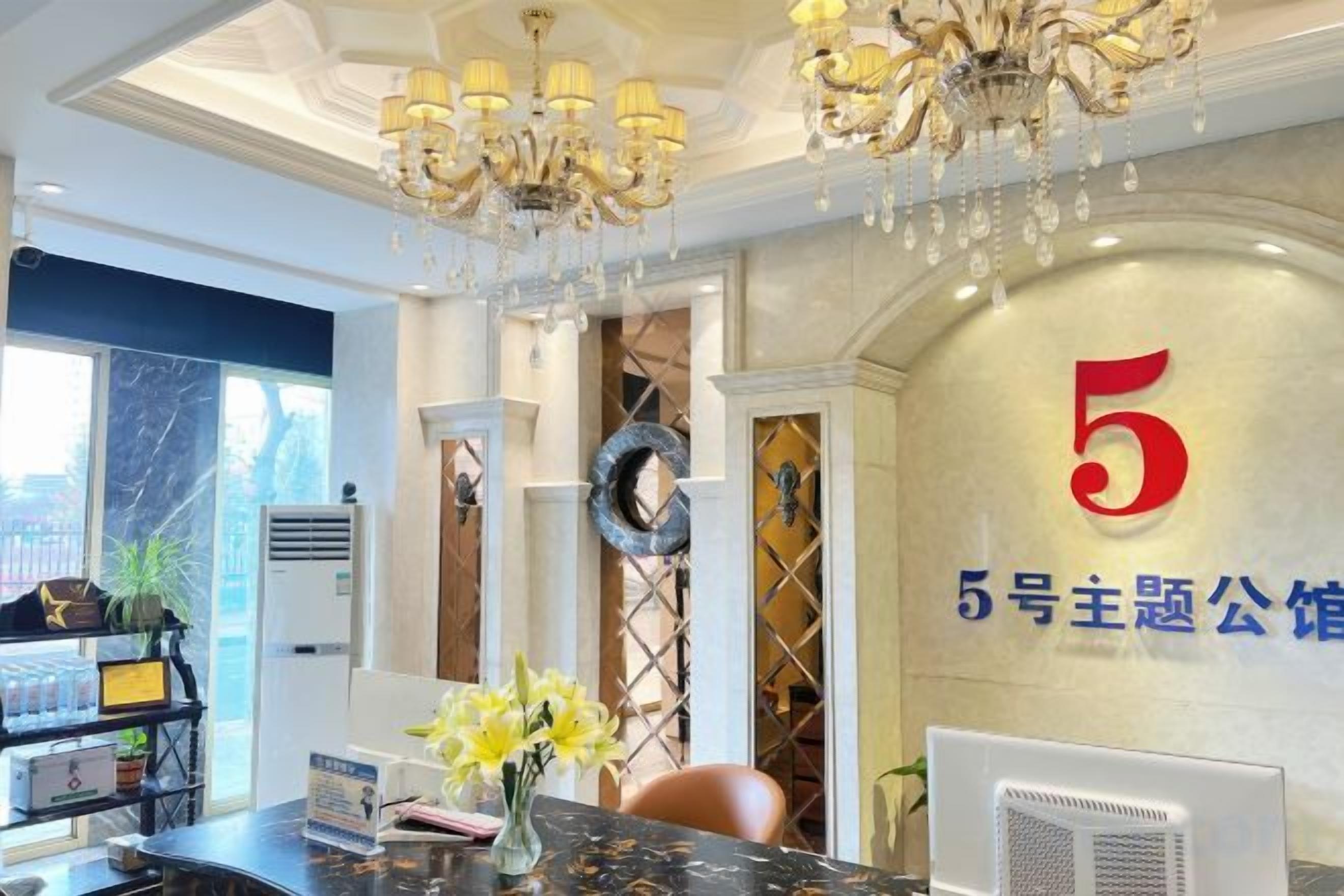 A reception area with a marble counter, a chandelier, and a wall with a large number '5'.