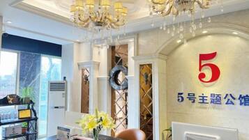 A reception area with a marble counter, a chandelier, and a wall with a large number '5'.