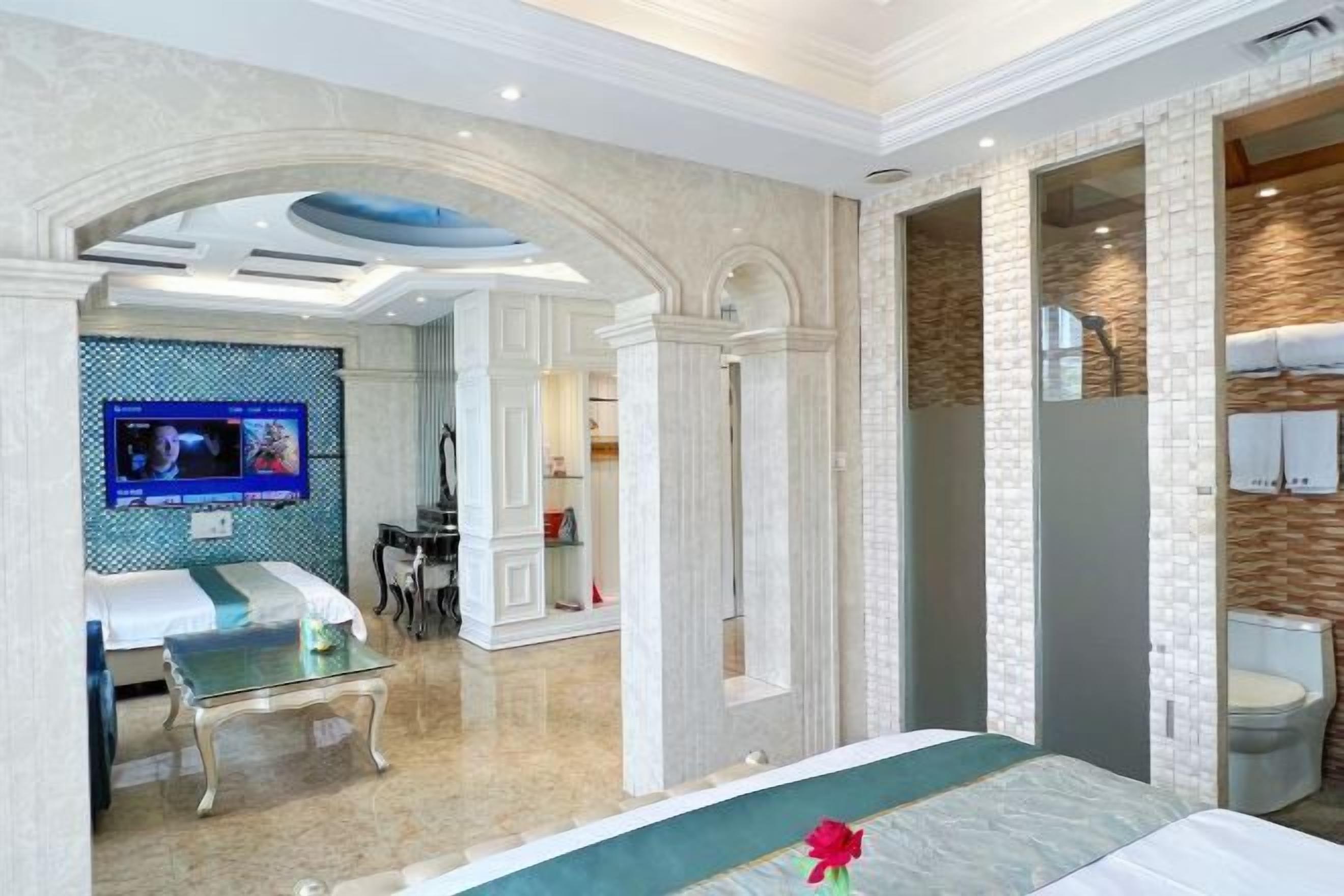 Une chambre d’hôtel avec un lit, une télévision, un bureau et une salle de bain.