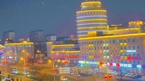 A multi-story building with a distinctive circular design and illuminated windows. - No.5 Theme Hotel (Yanji)