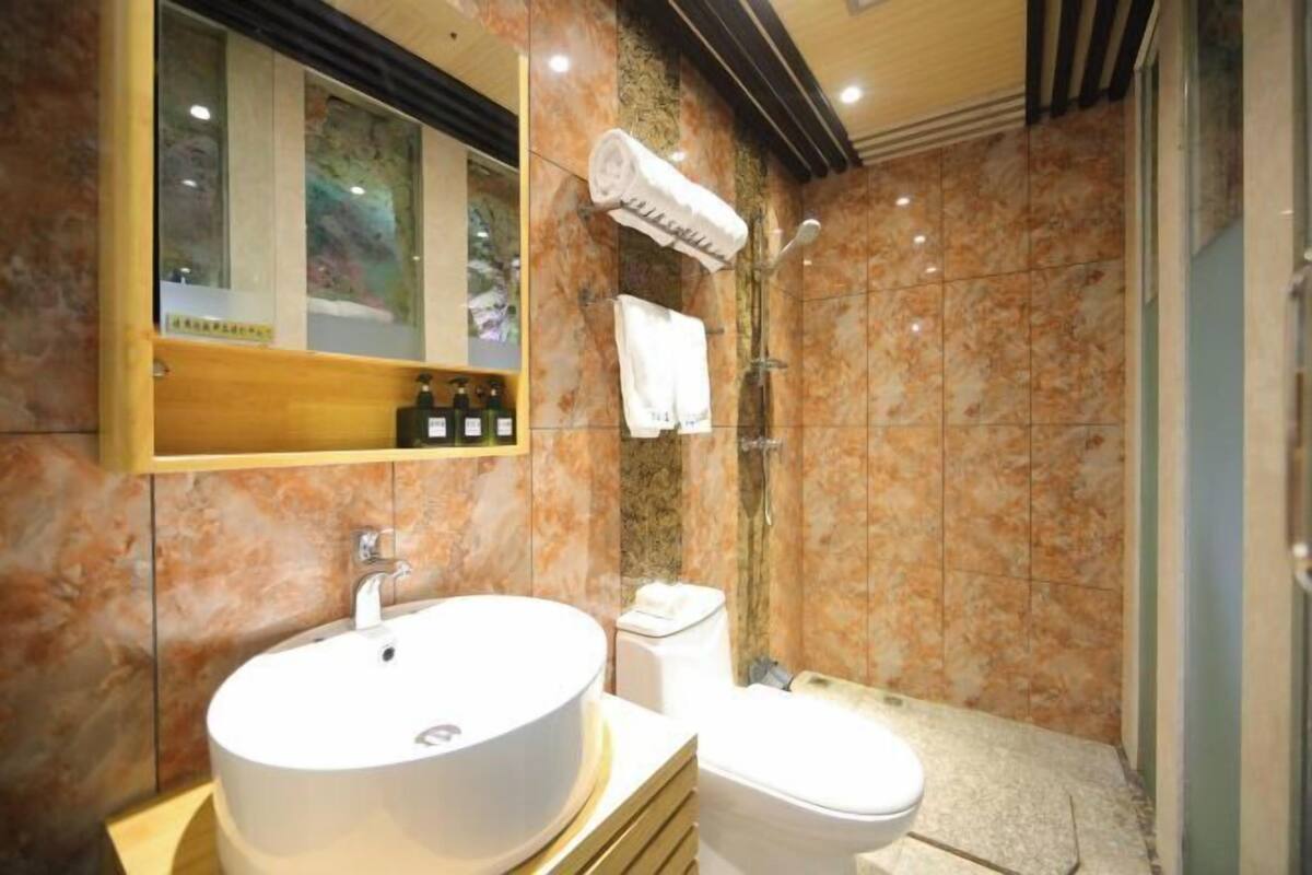 A bathroom with a large sink, toilet, and a shower area.