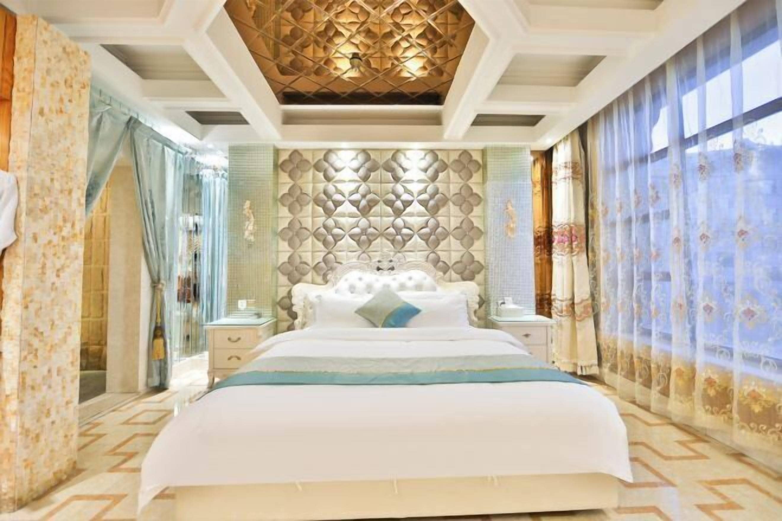 A spacious bedroom with a large bed, a decorative ceiling, and a patterned wall.
